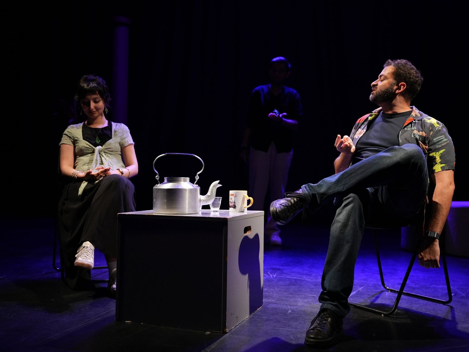 Karak kettle and chai mug on stage as performers improvise a scene
