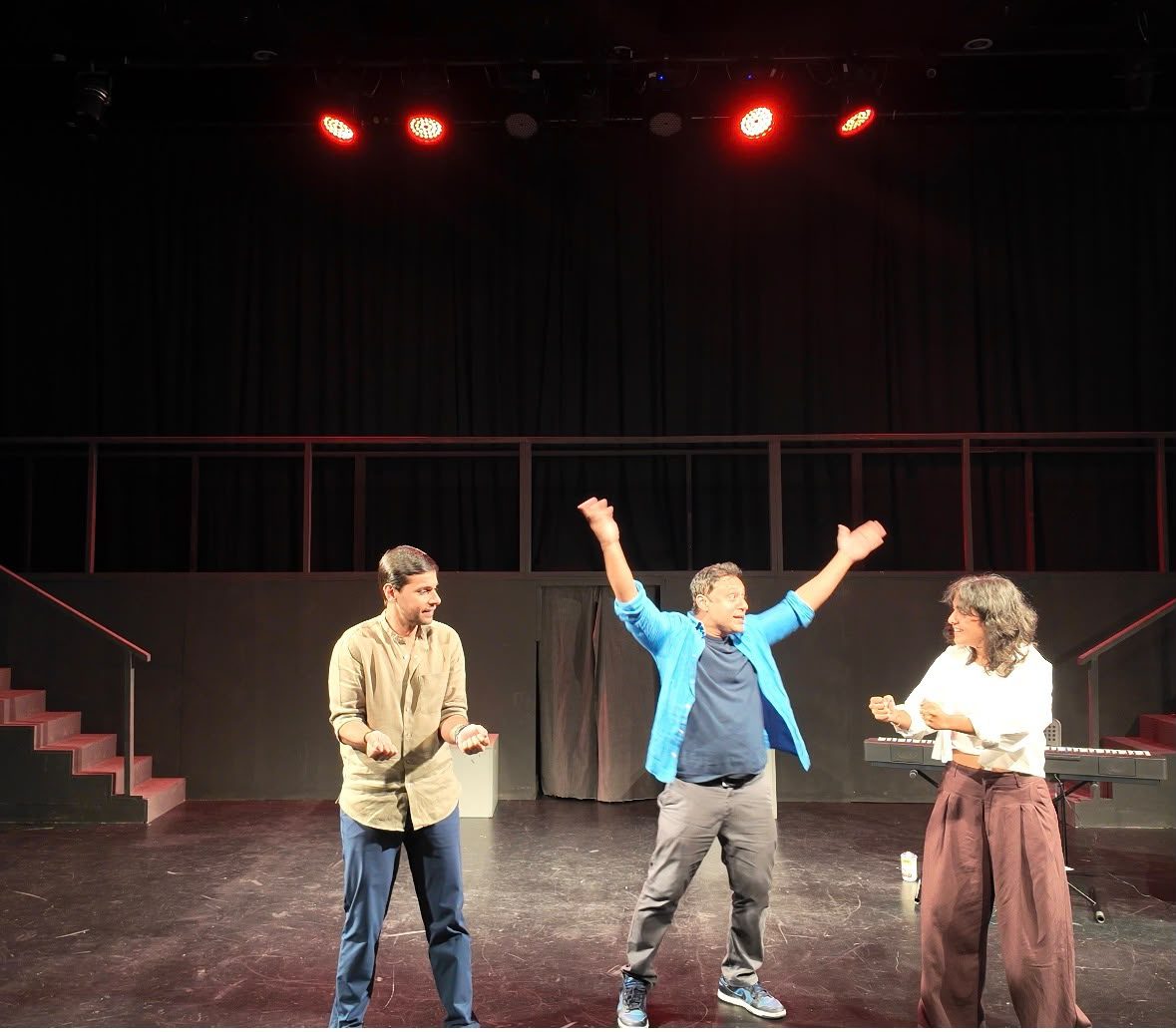 Improvisers mid-scene under red stage lights at an early Karak After Dark show